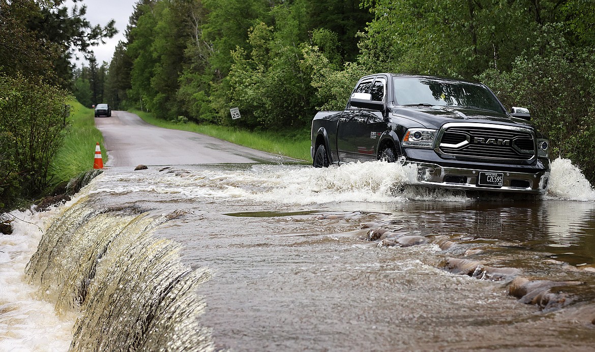 A pickup makes its way through the flooding along Garnier Creek on North Hilltop Road in Columbia Falls Wednesday, June 15. (Jeremy Weber/Daily Inter Lake)