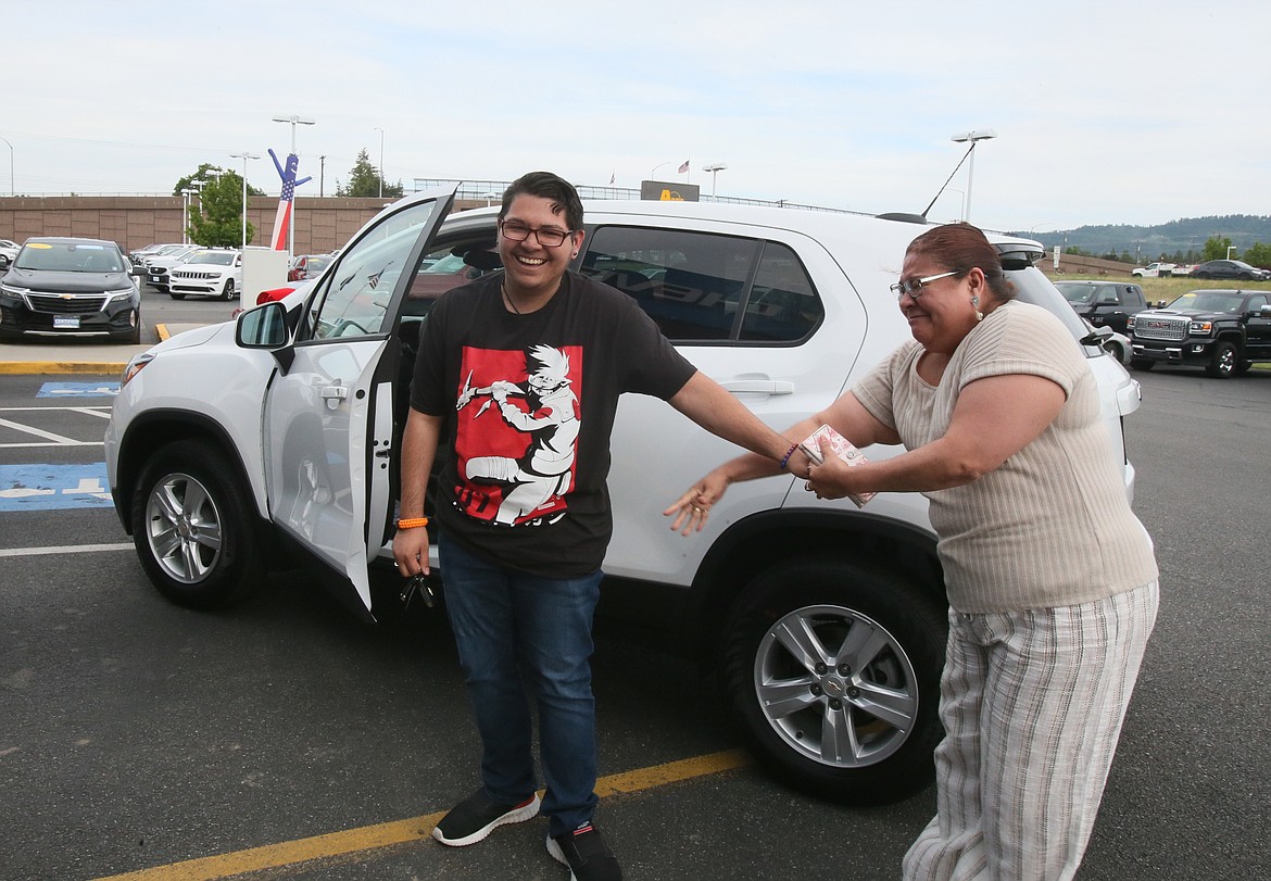 New car winner Malachi Silva shares a happy moment with his mom, Esther Delcomte, who overjoyed her son won a brand new car at Knudtsen Chevrolet on Thursday evening.