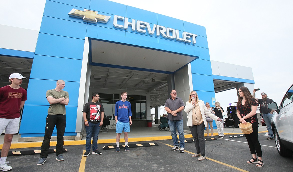 Knudtsen Chevrolet President Eve Knudtsen, with mic, announces the start of the high school graduate new car giveaway Thursday during the 83rd anniversary celebration of the Knudtsen Chevrolet dealership.