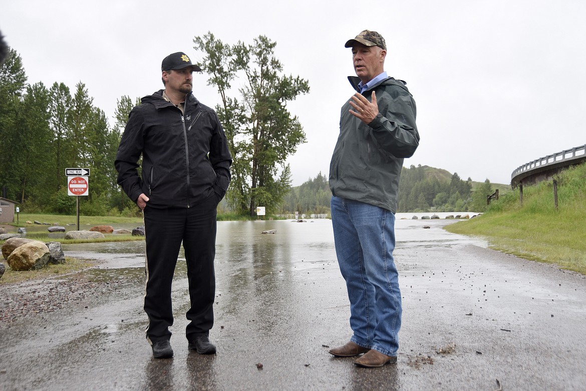 Flathead County Sheriff Brian Heino updates Gov. Greg Gianforte on flooding in Northwest Montana during a briefing Monday, June 20 at the Old Steel Bridge fishing access on the Flathead River in Evergreen. (Matt Baldwin/Daily Inter Lake)