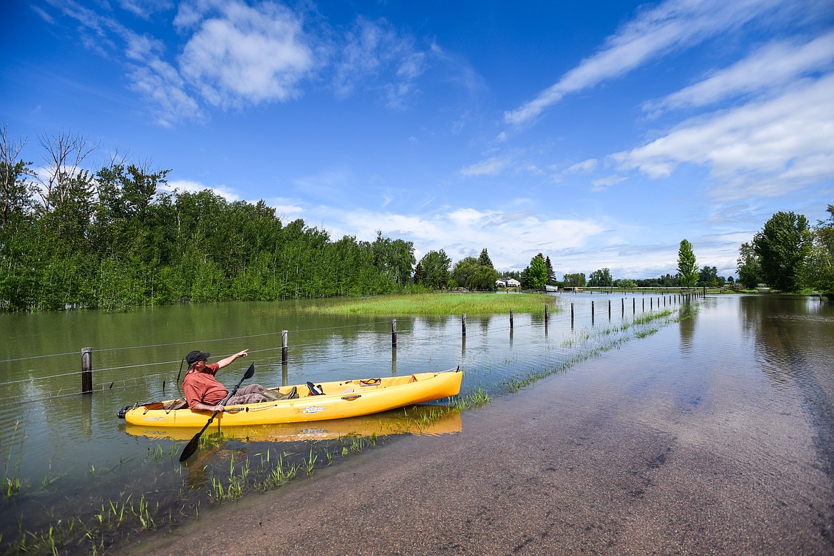 Robert Miller points back to his residence along Wagner Lane as he surveys flooding from the Flathead River on Tuesday, June 21. Miller measured 28 inches of standing water in some places near his property. He and five other residences at the end of Wagner Lane have chosen to stay through a pre-evacuation notice issued by the Flathead County Sheriff's Office.(Casey Kreider/Daily Inter Lake)