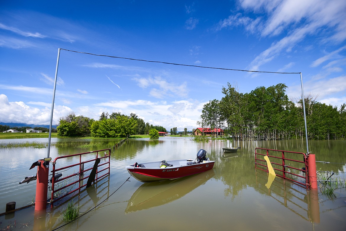 Two boats are tied in the flooded driveway of residences along Wagner Lane near the Flathead River on Tuesday, June 21. (Casey Kreider/Daily Inter Lake)