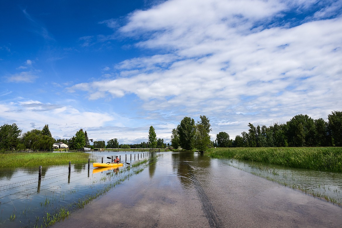 Robert Miller paddles a kayak away from his residence on Wagner Lane to survey flooding from the Flathead River on Tuesday, June 21. Miller measured 28 inches of standing water in some places near his property. He and five other residences at the end of Wagner Lane have chosen to stay through a pre-evacuation notice issued by the Flathead County Sheriff's Office.(Casey Kreider/Daily Inter Lake)