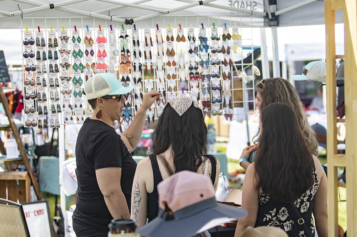 Local artisan Angela Collins of Divine Designs helps a group of festival shoppers with their selections during the inaugural Music in the Missions hosted in St. Ignatius on Friday.
