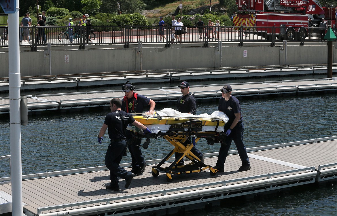 Northern Lakes Fire District personnel transport an injured person to an ambulance on Tuesday at the Third Street dock.