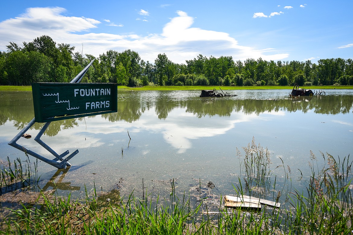 Old farm equipment sits in floodwaters from the Flathead River along Wagner Lane on Wednesday, June 22. (Casey Kreider/Daily Inter Lake)