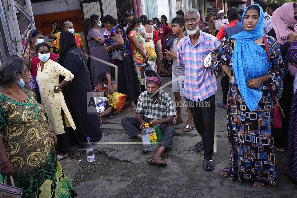 People wait near an empty fuel station hoping to buy kerosene oil for cooking in Colombo, Sri Lanka, Thursday, May 26, 2022. Sri Lanka's economic crisis, the worst in its history, has completely recast the lives of the country's once galloping middle class. For many families that never had to think twice about fuel or food, the effects have been instant and painful, derailing years of progress toward lifestyles aspired to across South Asia. (AP Photo/Eranga Jayawardena, file)