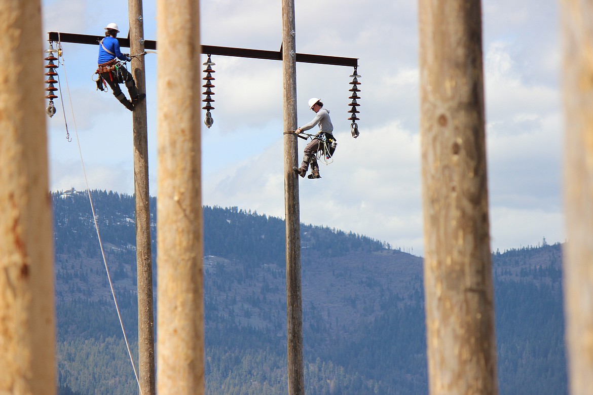 Lineworker students Joel Emery, right) from Hoquiam, Wash., and Ryson Patterson, from Astoria, Ore., climb up and down poles on the Rathdrum Prairie recently as part of the 10-week VOLTA program. For this first class, many of the students were recruited from all over the Northwest, but prospective North Idaho students are encouraged to register for future classes.