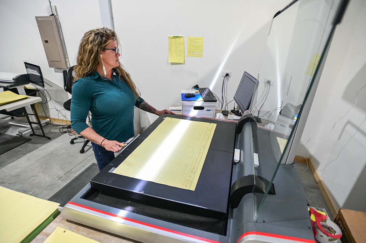 Mary Stewart scans pages from a book of Sanders County records using a Zeutschel overhead scanner at Global Archives on Wednesday, June 22. (Casey Kreider/Daily Inter Lake)