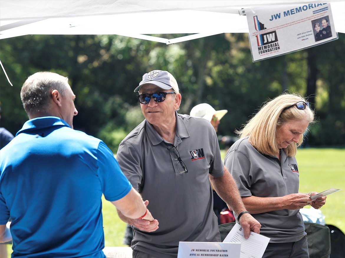 Robert Tyler, JW Memorial Foundation board member, shakes hands with a guest during the “BBQ for Heroes” at McEuen Park on Wednesday.