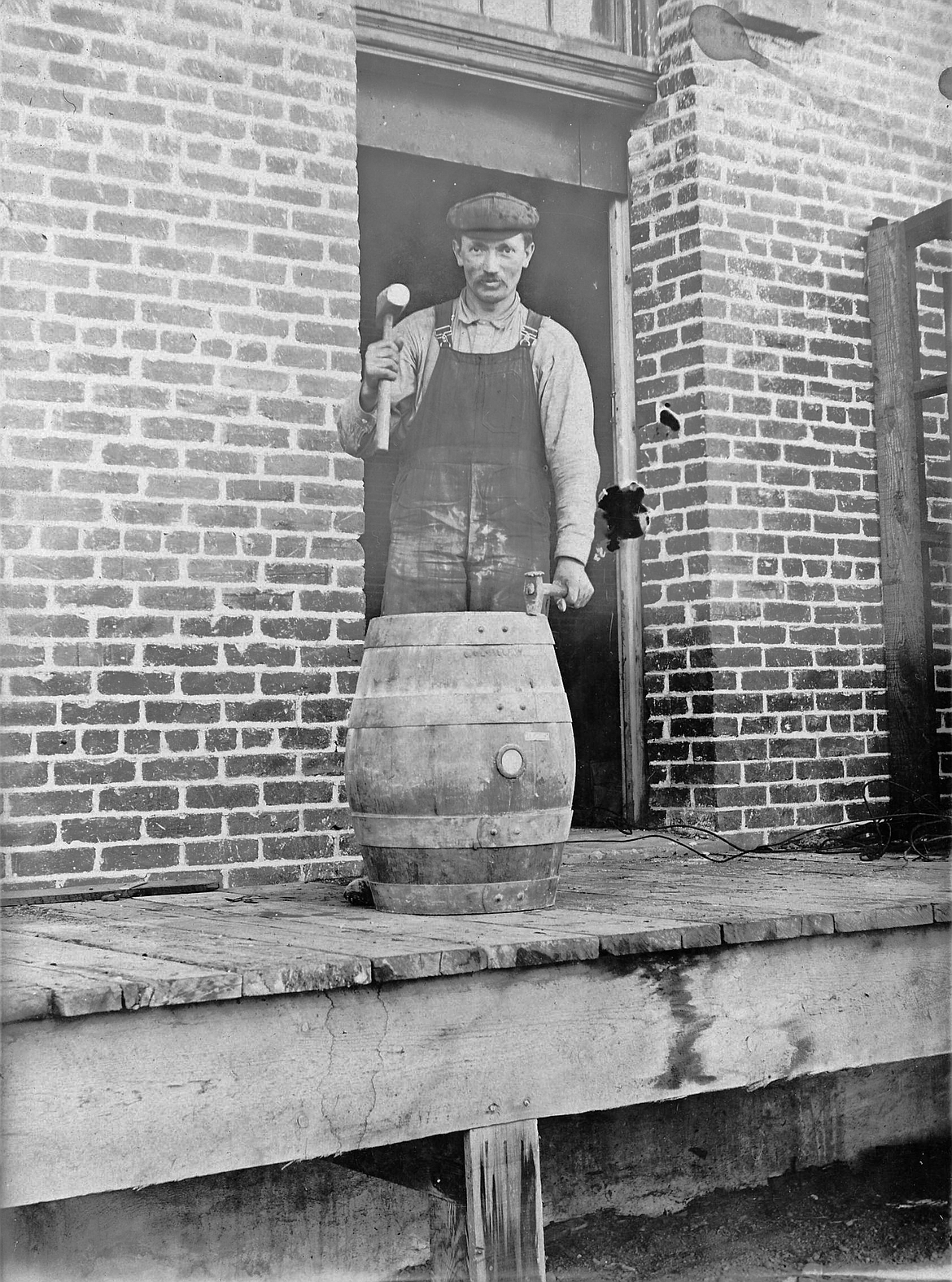 Panhandle Brewery workman putting the top hoop on a wooden beer keg, circa 1913.