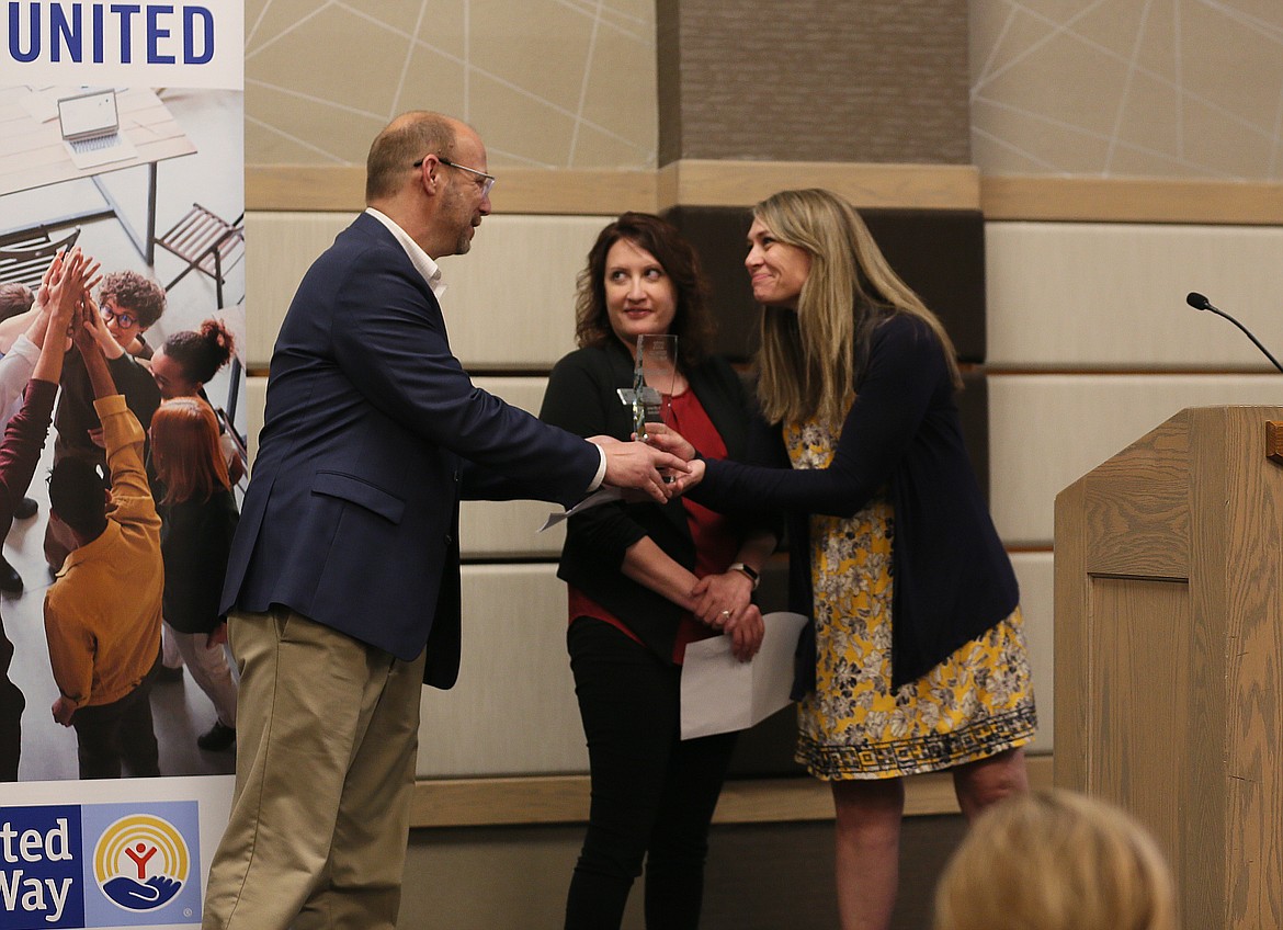 United Way of North Idaho Board President Jason Livingston presents Debi Alsager's daughter Tiffany Pettit, right, with the volunteer of the year award, which Pettit accepted on her mom's behalf. Holly Johnson, who nominated Alsager for the award, is pictured in the center.