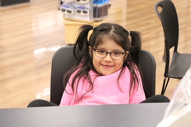 A Moses Lake School District student shows off her new glasses, purchased through the district’s migrant program.