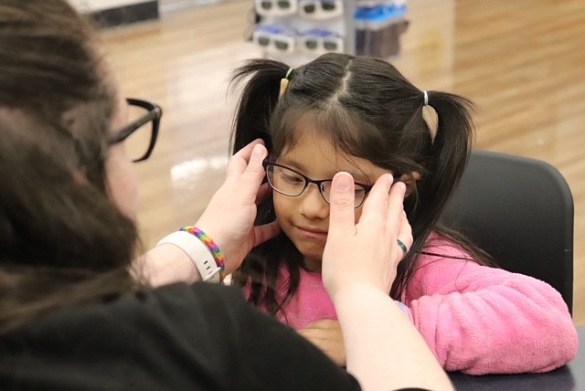 A joint project with the Vision Center helped administrators in the Moses Lake School District migrant program get glasses for children, including a student being fitted with a new pair.