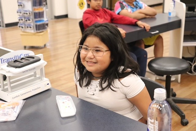 A Moses Lake School District student smiles in satisfaction at her new glasses.