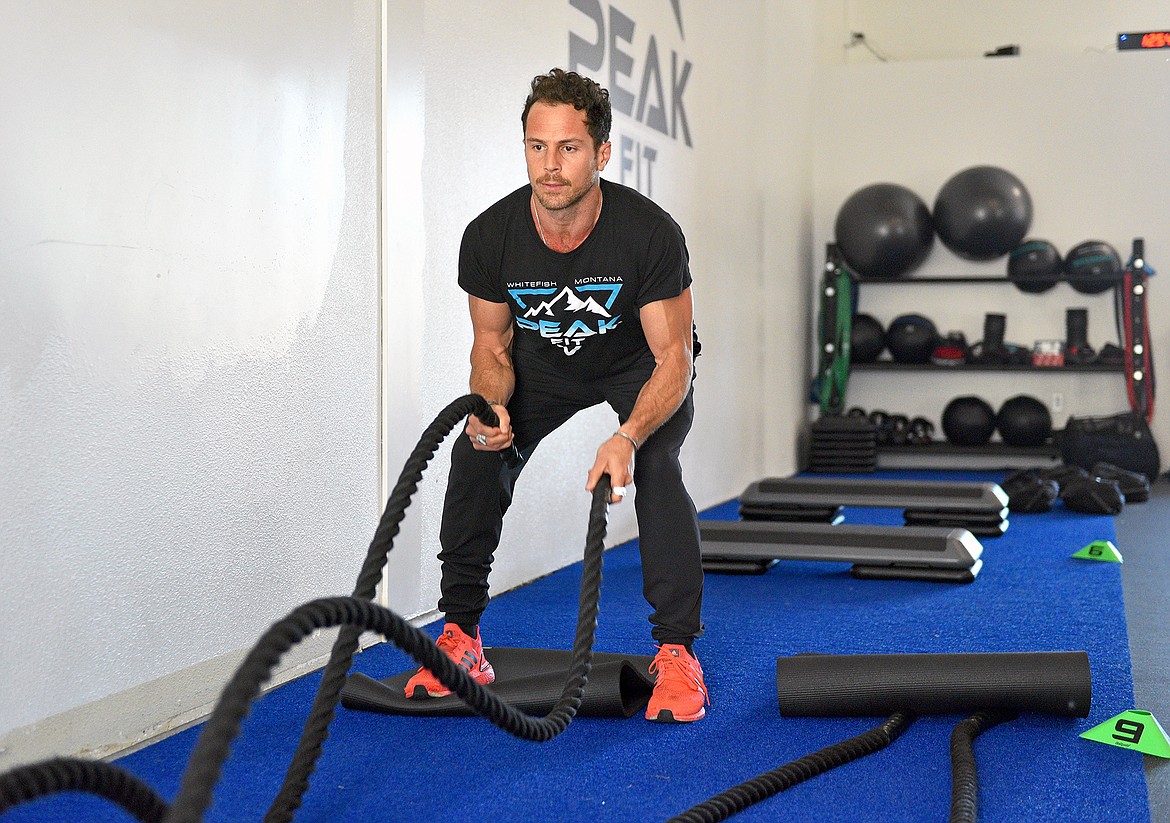 PEAK Fit head trainer Andre Bolourchi shows how to use the battle ropes in the Whitefish gym on Thursday. (Whitney England/Whitefish Pilot)