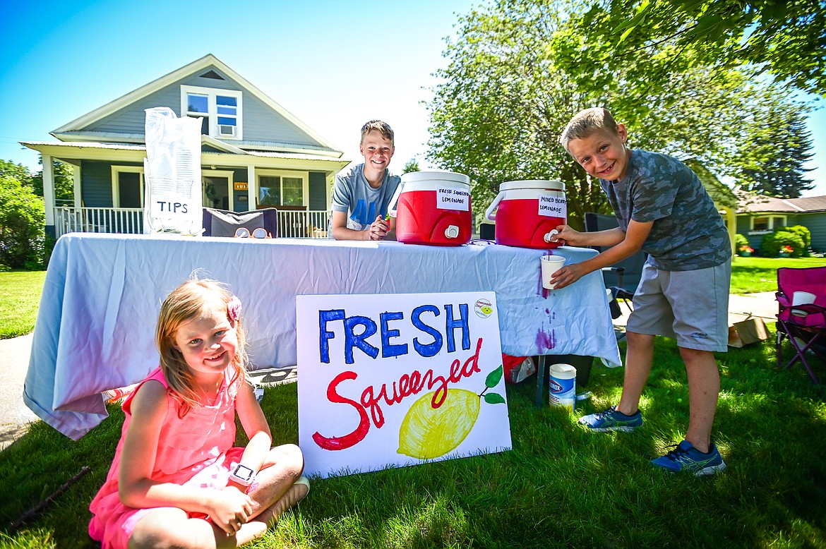 From left, Clara, Ethan and Logan Spratling operate their Fruity Lemonade stand as part of Lemonade Day in Kalispell on Saturday, June 25. The national Lemonade Day program helps youth learn about starting a business, via the one-day stands. Through guided lessons in their Lemonade Day booklet, they learn about budgeting, finance, site selection, product creation, supplies, staffing, and more. (Casey Kreider/Daily Inter Lake)