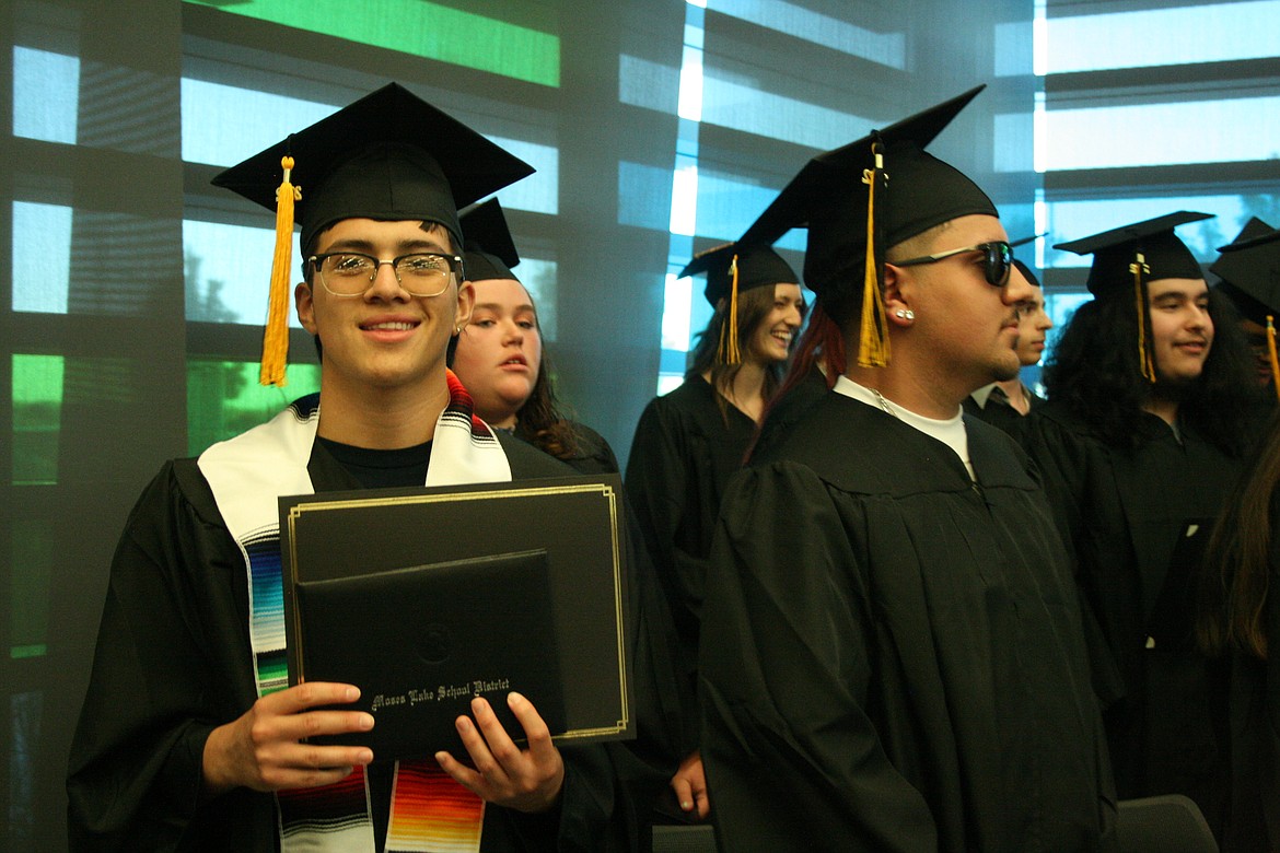 An Open Doors graduate displays his diploma during Thursday’s ceremony.