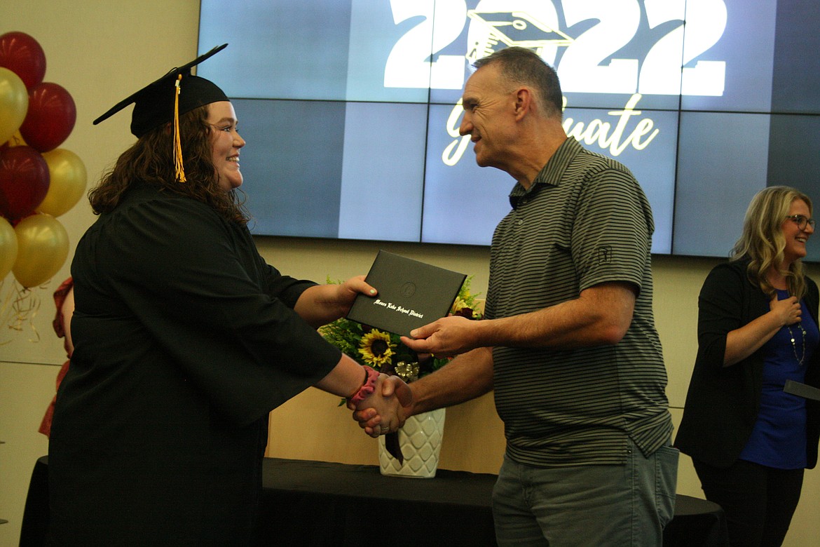 An excited graduate receives her diploma from Moses Lake School Board member Kevin Fuhr during the Open Doors graduation ceremony Thursday.