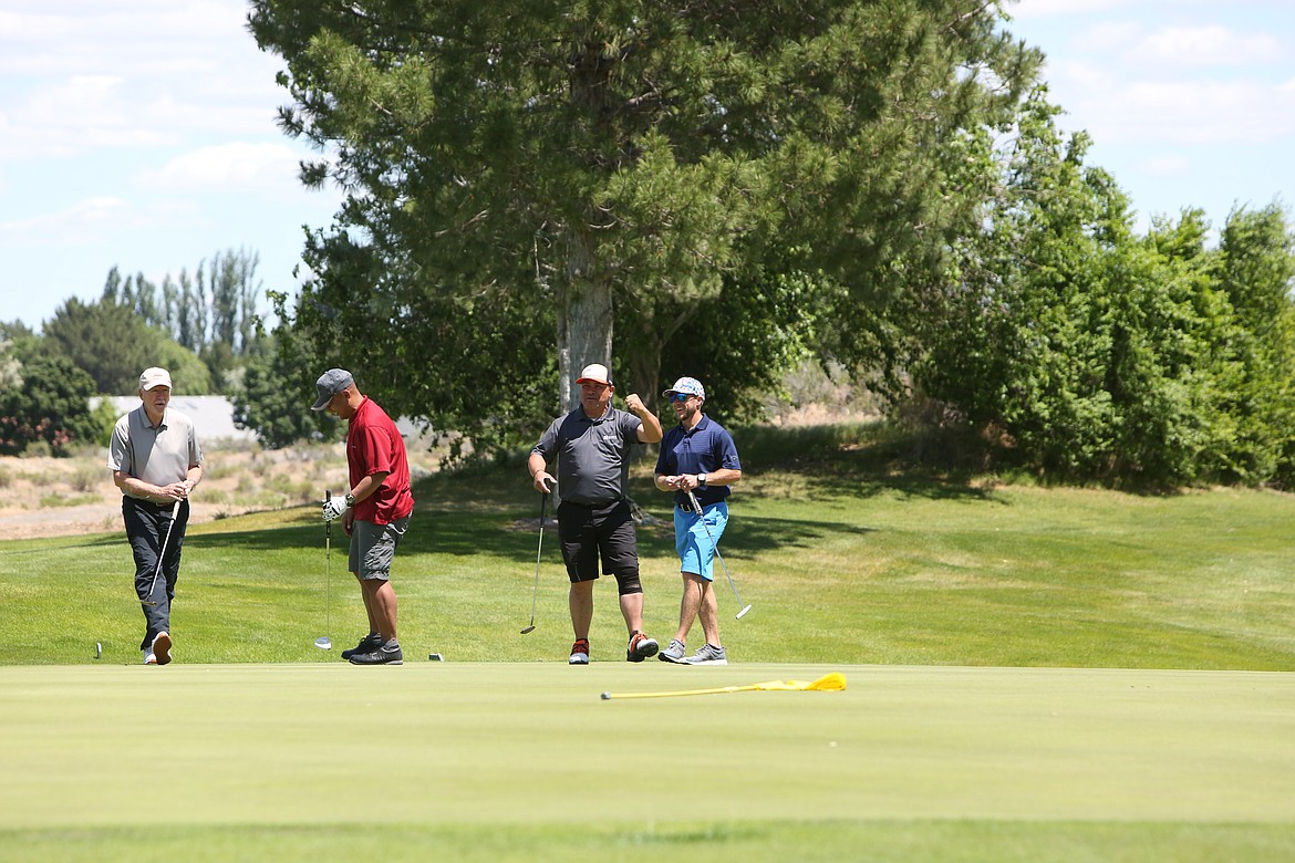 Numerous golfers from around the area came out to the Moses Lake Golf Club, including this group celebrating after a putt.