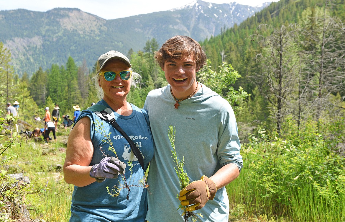Dawn LeFleur and her son, Nico, pulling weeds along the Flathead River during the Weed Rodeo. (Julie Engler/Whitefish Pilot)