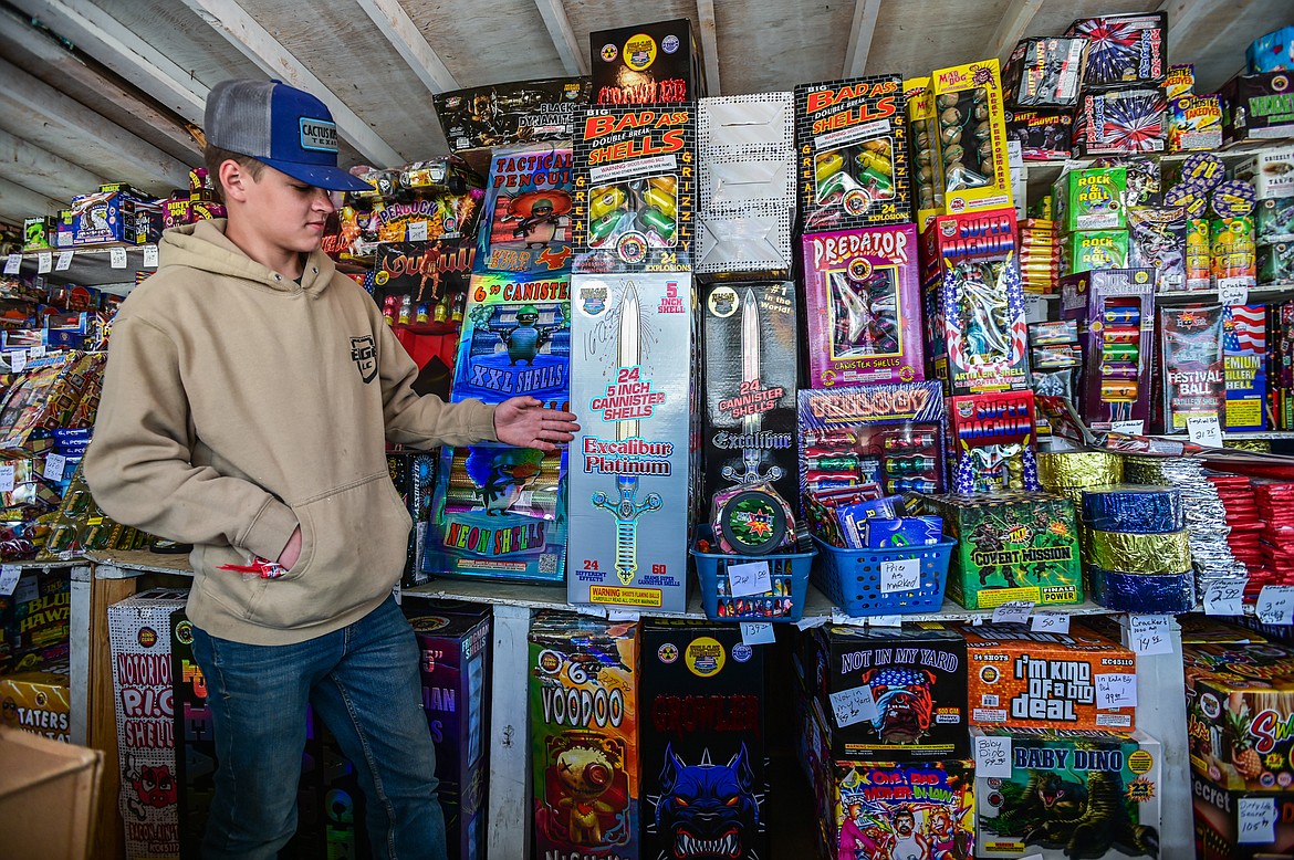 Haakon Erickson points to a section of canister shell fireworks at the Robinson's Fireworks stand in Evergreen on Wednesday, June 29. (Casey Kreider/Daily Inter Lake)