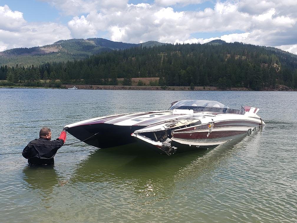 A Bonner County Sheriff's Office dive team member helps bring a boat into shore Wednesday morning after the boat capsized the night before near Thama. Three people are missing and one boater has been found deceased.
