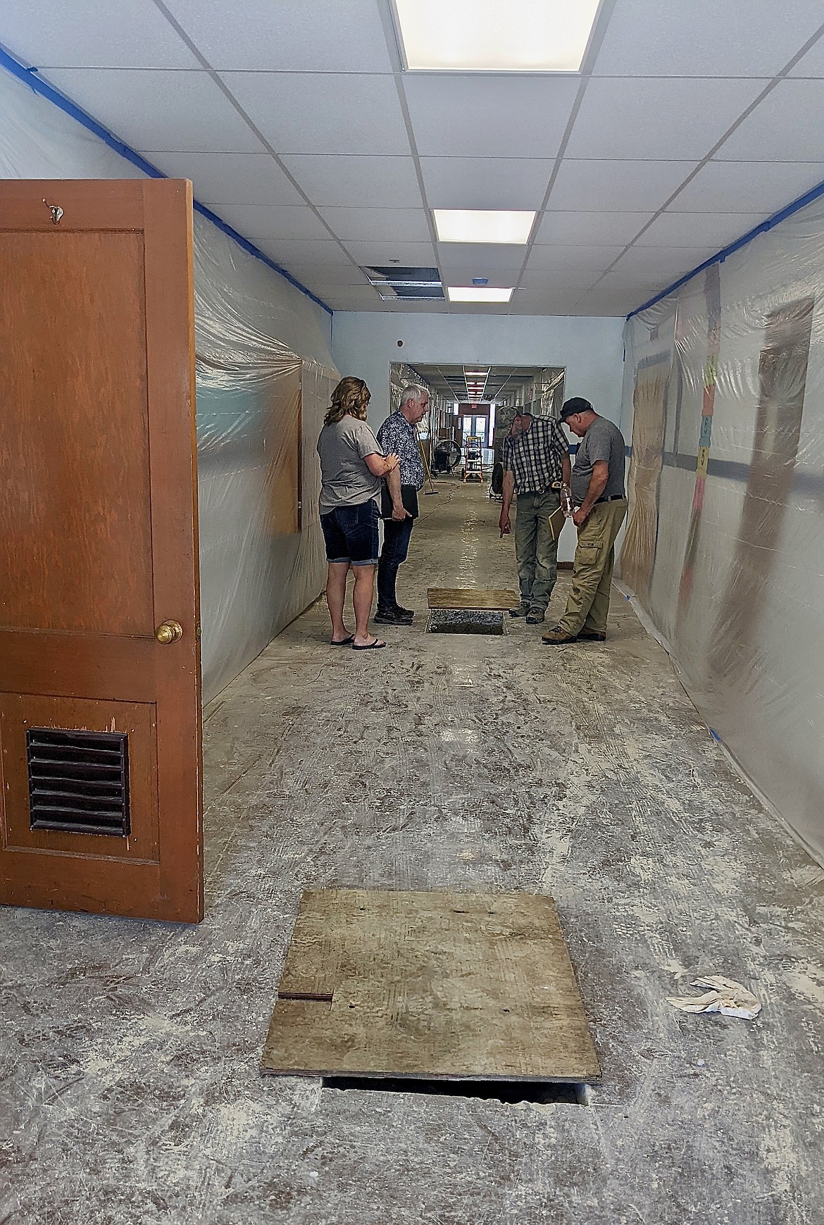 Bf Builders and Trustee Teresa Rae inspect the sewer lines in the hallway at Mt. Hall Elementary.