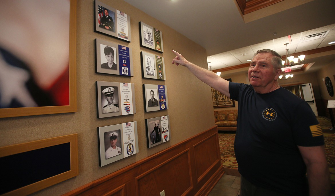 Resident Clay Ostergren points to where his military photo hangs above his wife's on the Garden Plaza Wall of Honor. A ribbon cutting and dedication ceremony to honor Garden Plaza's veterans will be held July 5.