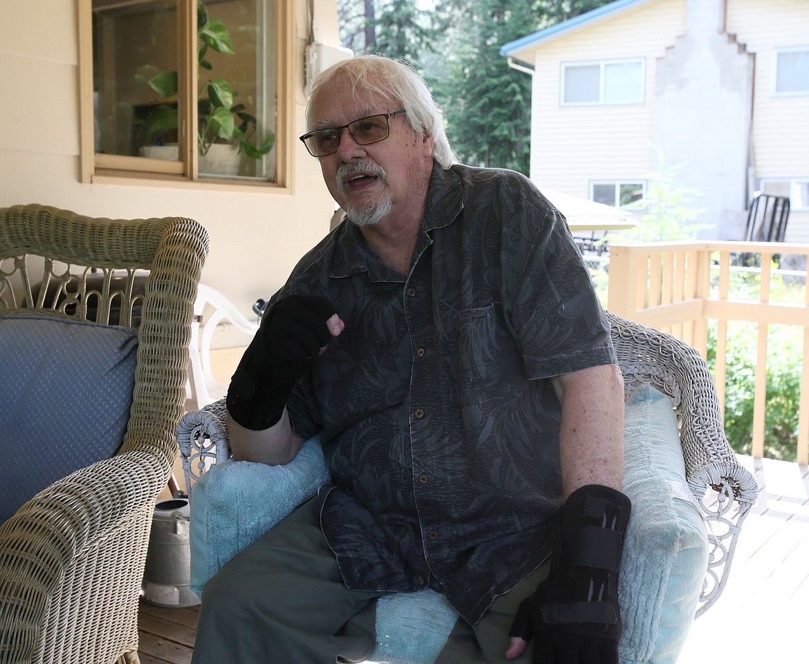 Disabled Vietnam veteran and seascape artist John Jennings recites a poem while seated on his back deck Thursday.