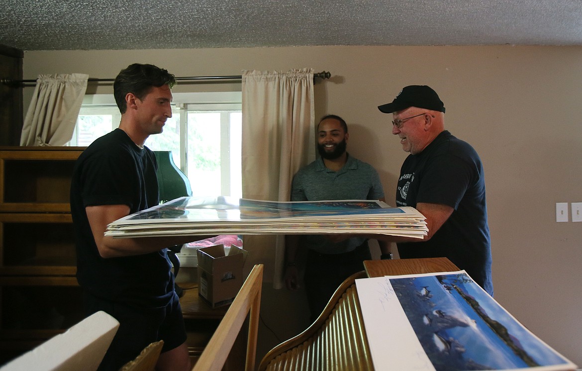 Hakuna Matata Moving owner Cody Lawson, center, oversees the transport of John Jennings' art prints as they're moved by Hakuna Matata team member Tom Newton, left, and American Legion Post 143 adjutant Tim Shaw.