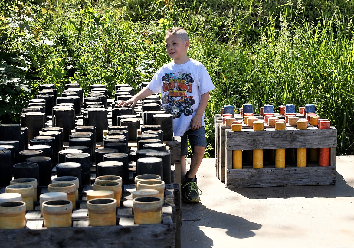 Marshall Vaughan, son  of Dalton Vaughan of Pyro Spectaculars stands next to the mortars as they're being set up for the Fourth of July fireworks show over Lake Coeur d'Alene,