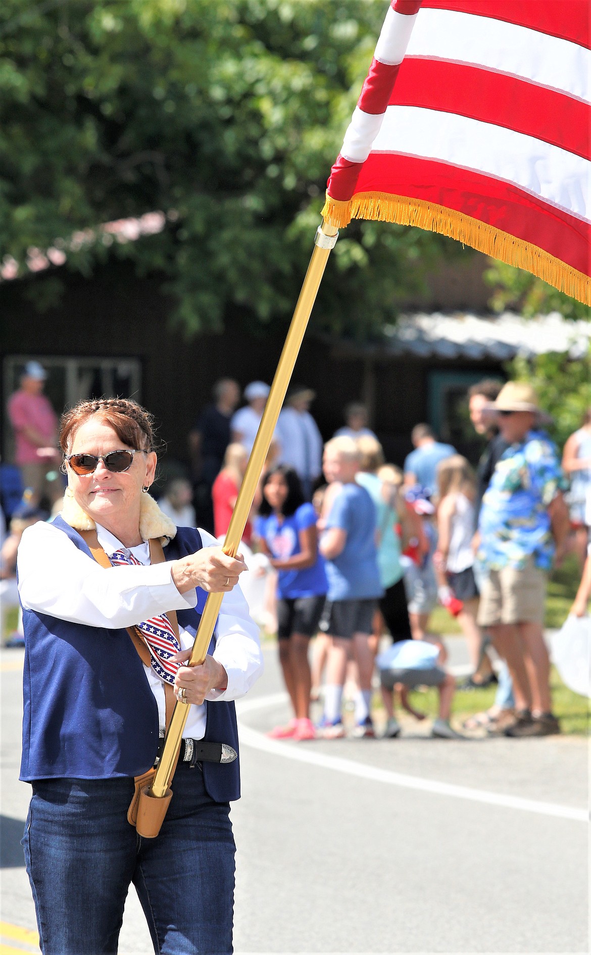 Sherry States with American Legion Post 149 Women's Auxiliary carries a flag in the Bayview Daze Parade.