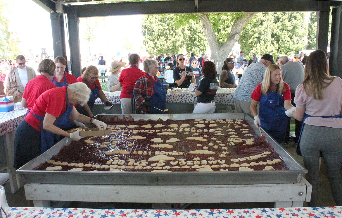 Members of the Georgettes prepare to serve up slabs of what’s been billed as the world’s largest cherry pie at George’s Independence Day celebration Monday.