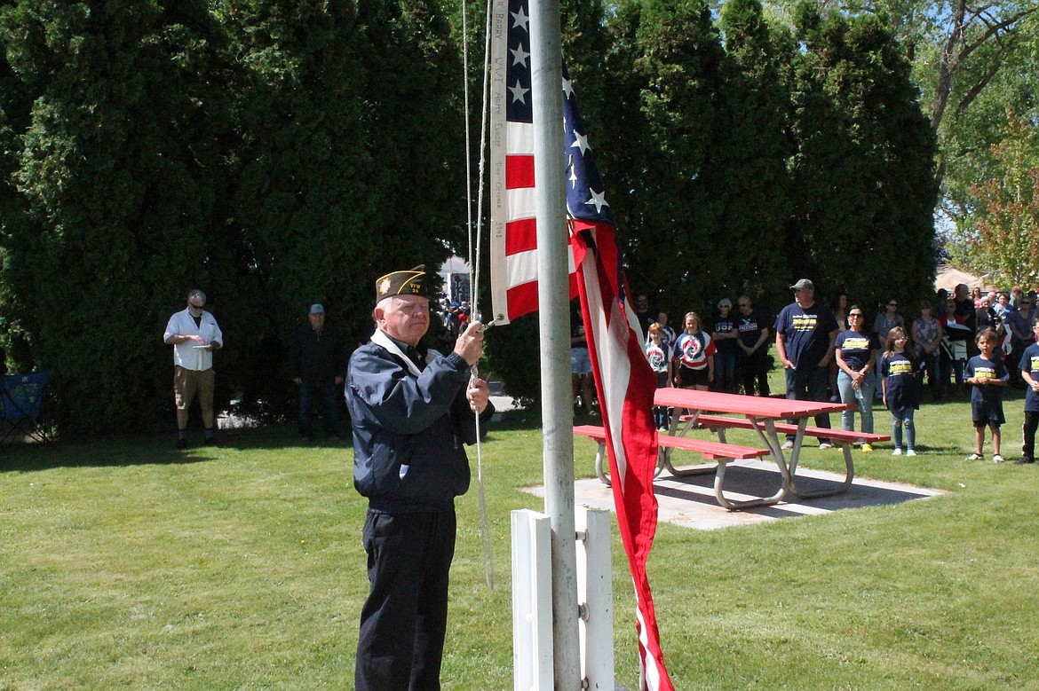 Jim Devany of Quincy raises the Stars and Stripes at George’s Independence Day celebration Monday.