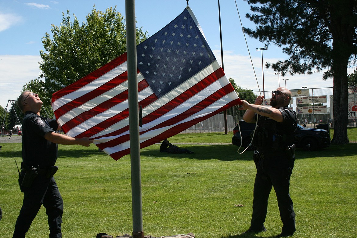 Othello Police Chief Phil Schenck (left) and OPD Sgt. Seth Carlson raise the flag in Lions Park during the annual July 4 celebration.