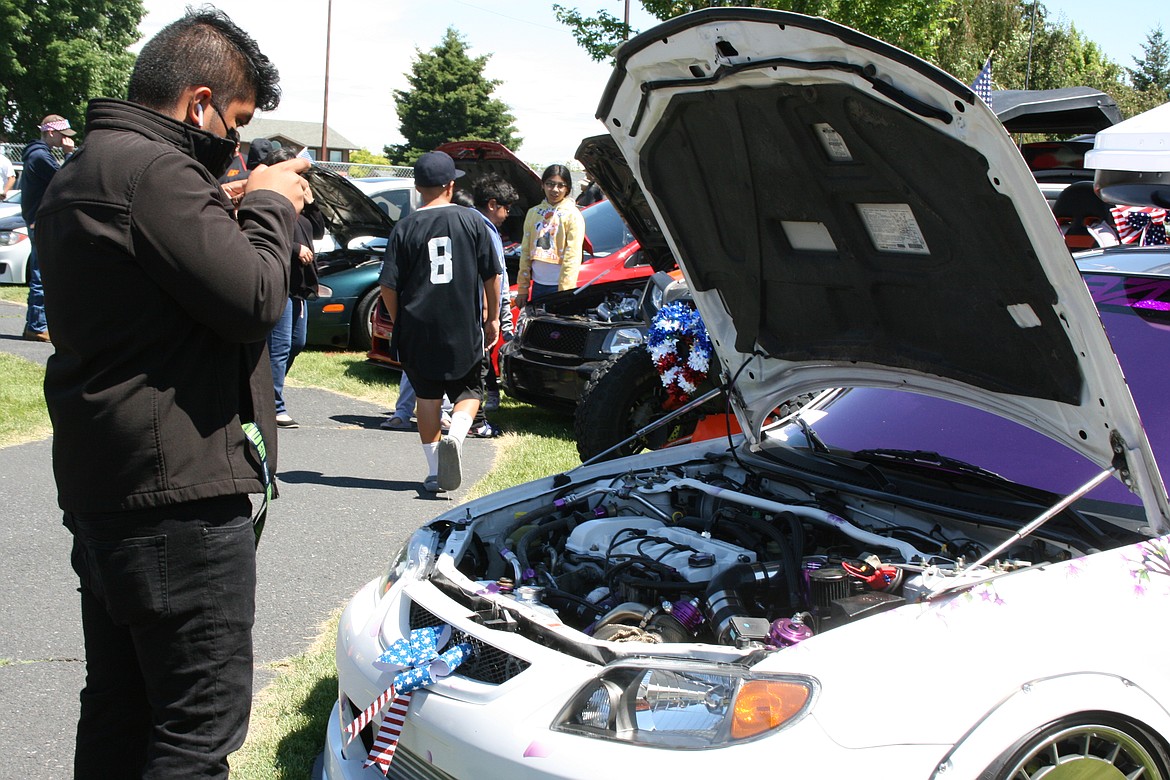 A spectator snaps a picture of an interesting engine compartment during the car show in Othello July 4.