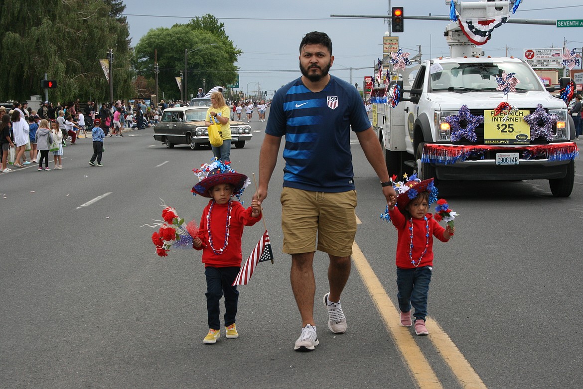 A pink and white Mazda leads a contingent of cars down the parade route in Othello July 4.