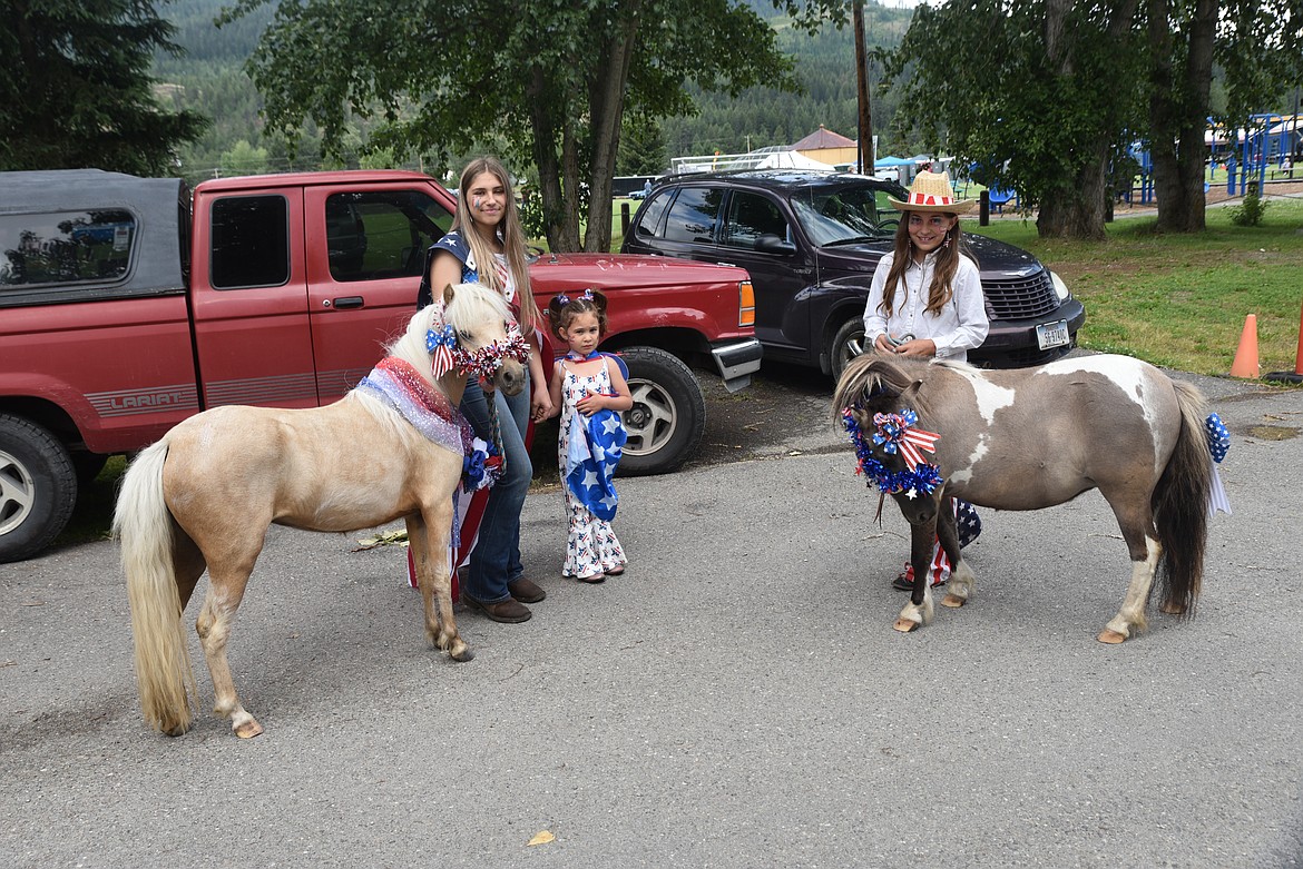 From left, Brooklyn Reid, with Dream, Kootenai Borgmann, and Ary Borgmann, with Juneau, prepare on Monday for the parade during Troy's Old Fashioned Fourth of July celebration. (Scott Shindledecker/The Western News)
