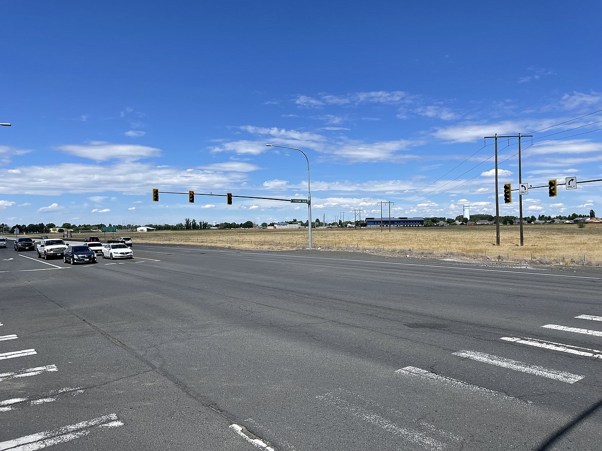 Motorists waiting for the light to change in the southbound lanes of S.R.17 at the highway’s intersection with Yonezawa Boulevard. The city of Moses Lake has plans to extend Yonezawa to the east — toward Groff Elementary School in the distance — but to do so will have to let the state convert the intersection into a roundabout.