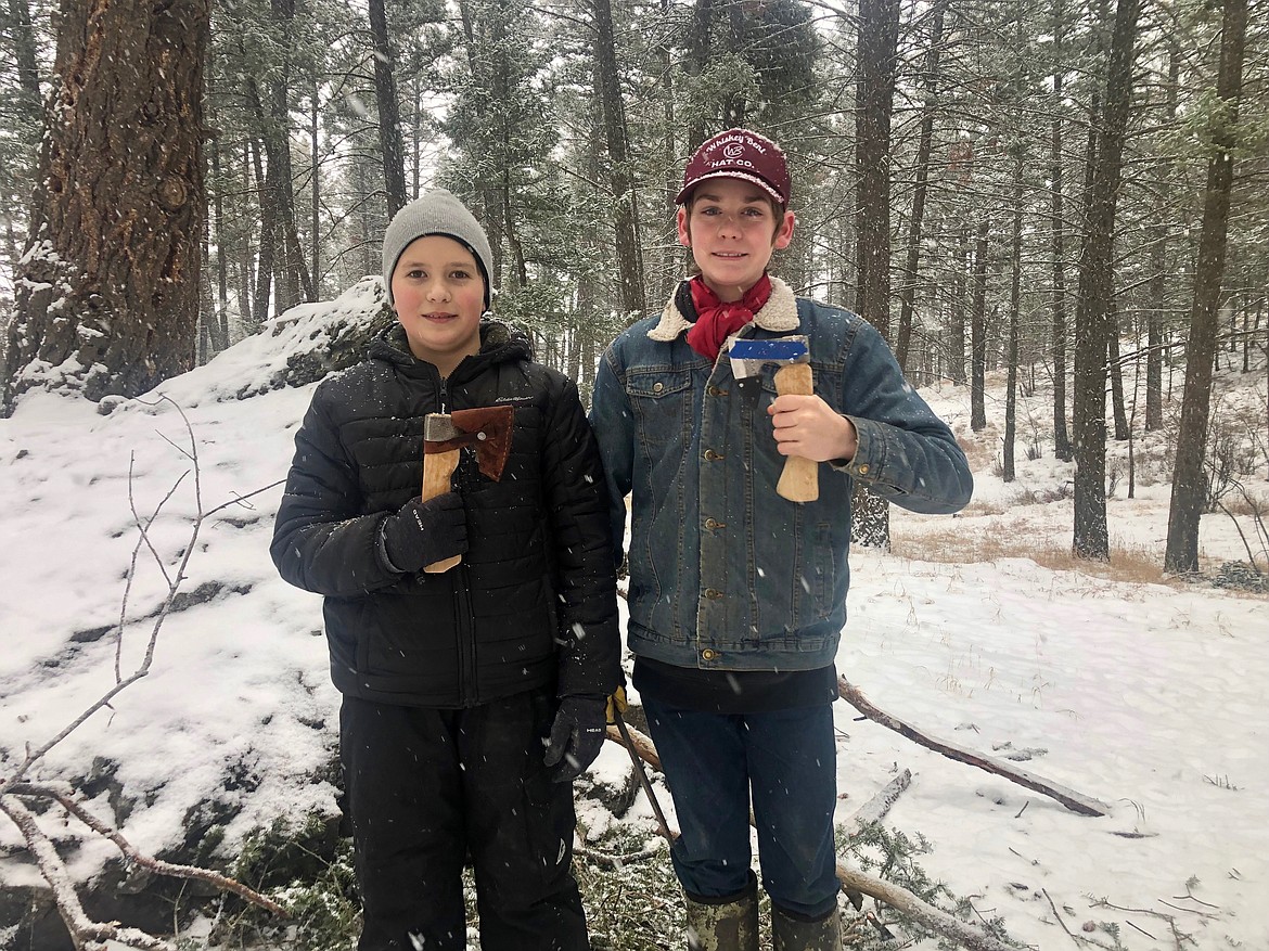 Montana Hybrid Academy students Zander Tekosis and Wyatt Kitchen show off hatchets and leather sheaths they learned to make (with the exception of the forged blades) during a "bushcraft day" at Lone Pine in February 2022. Bushcraft days are academy students meet in person to learn outdoor skills and participate in various educational projects and activities. The academy is opening up bushcraft days to other interested students in the public starting in the 2022-23 school year. (Courtesy photo)