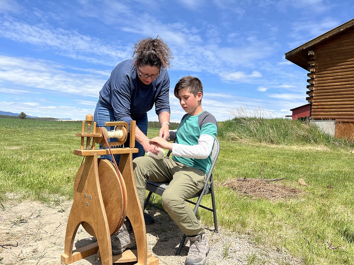 Montana Hybrid Academy student Abraham Chentnik learns how to use a spinning wheel during a May 2022 "bushcraft day" where students also learned how to spin wool into yarn using drop spindles they built. Bushcraft days are where students meet in person to learn outdoor skills and participate in various educational projects and activities. The academy is opening up bushcraft days to other interested students in the public starting in the 2022-23 school year. (Courtesy photo)