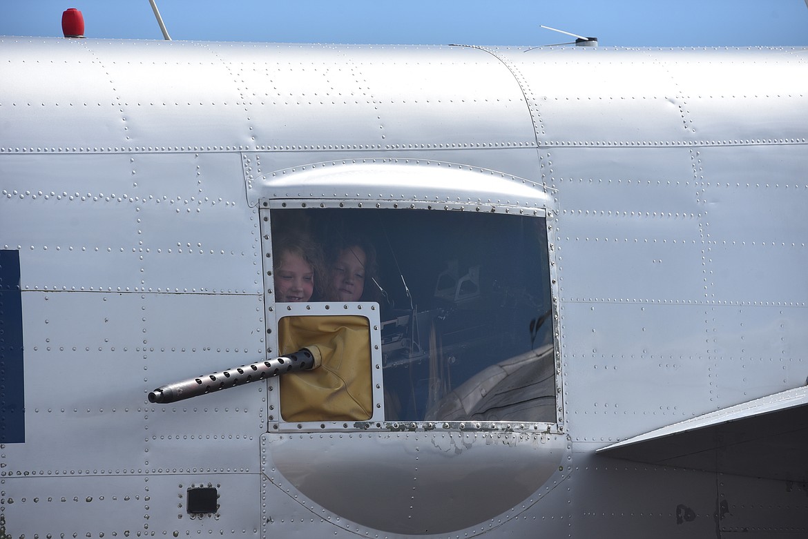 Twins Lela and Linnea Birkenstock examine a machine gun mounted aboard Maid in the Shade, a B-25J Mitchell and combat veteran of World War II. The aircraft was on display at Glacier Park International Airport on Wednesday, July 6, 2022. (Derrick Perkins/Daily Inter Lake)