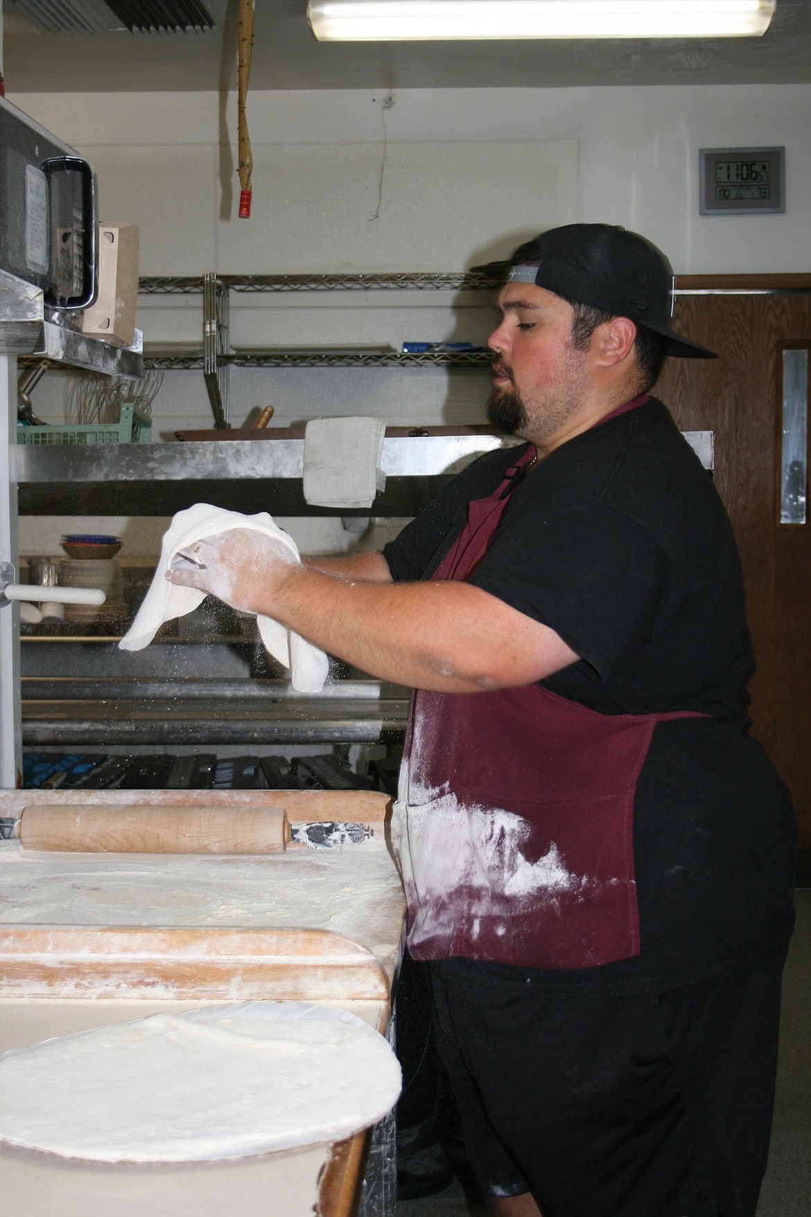 CJ Garza, co-owner of Timeout Pizza, gets pizza dough ready for the oven.