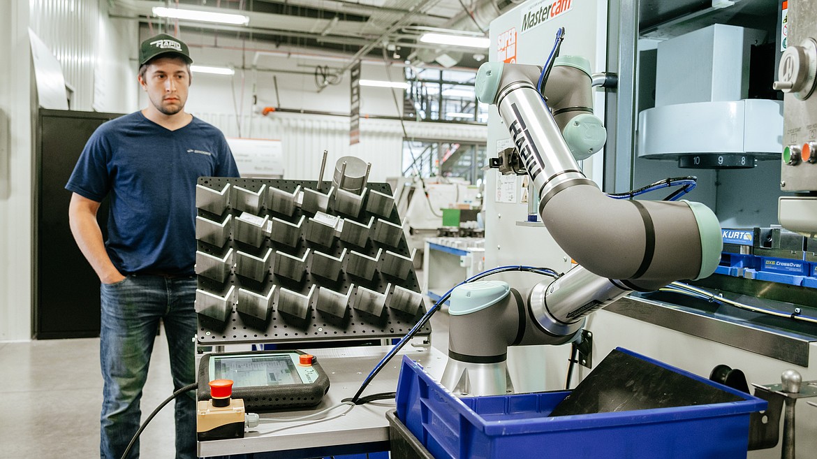 Kjel Davidson with Rapid Design Solutions LLC watches as an automated robot system transports raw material to a Mini Mill CNC machine during a robot demonstration event for regional companies Thursday at NIC’s Parker Technical Education Center in Rathdrum.