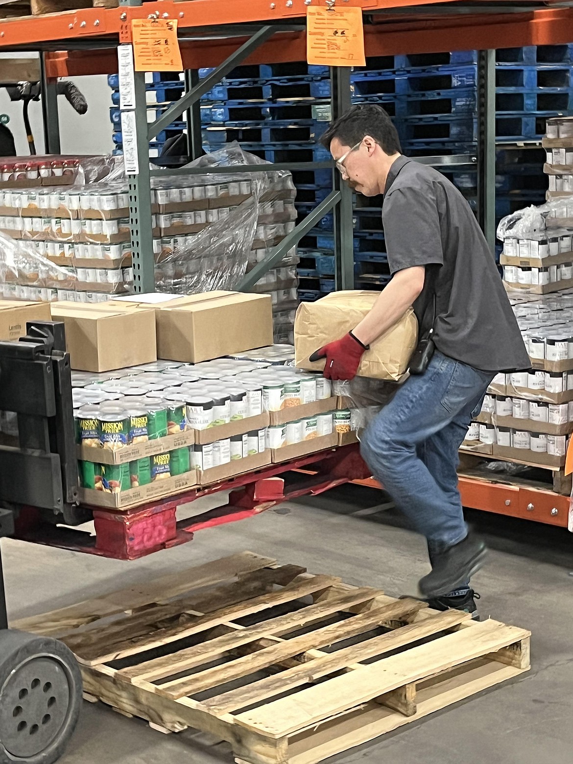 Brandon Vasquez on Friday moves inventory for the emergency food assistance program at Second Harvest.