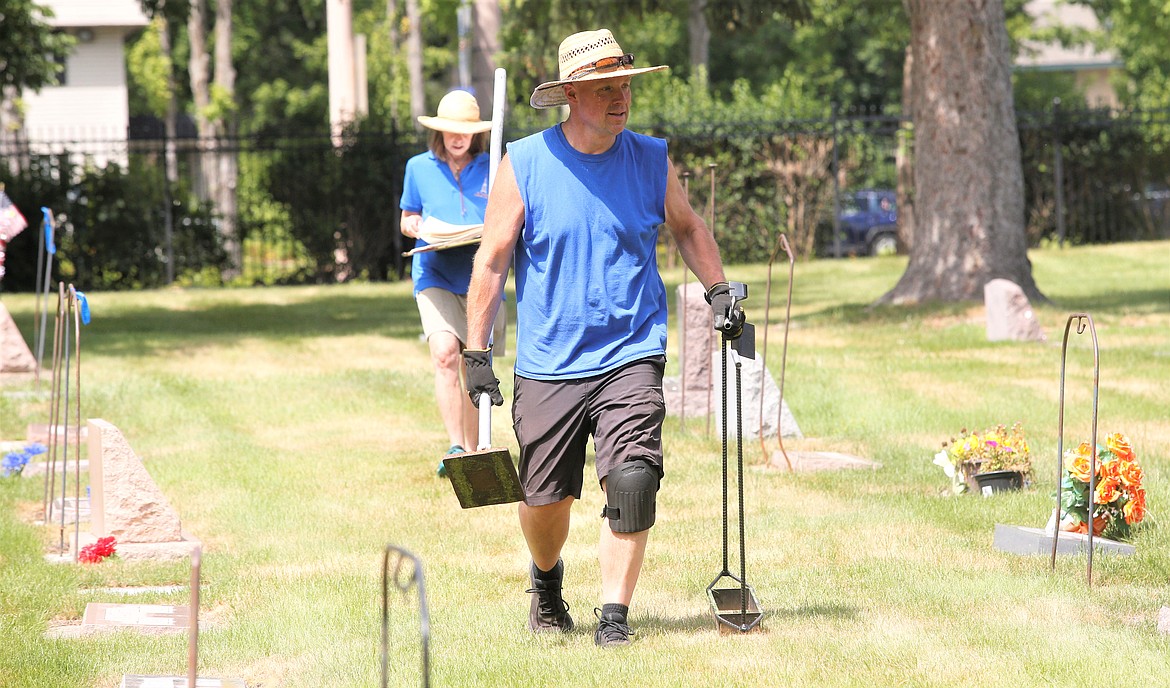 Mike Kopf and Tina Johnson walks through St. Thomas Cemetery on Friday.