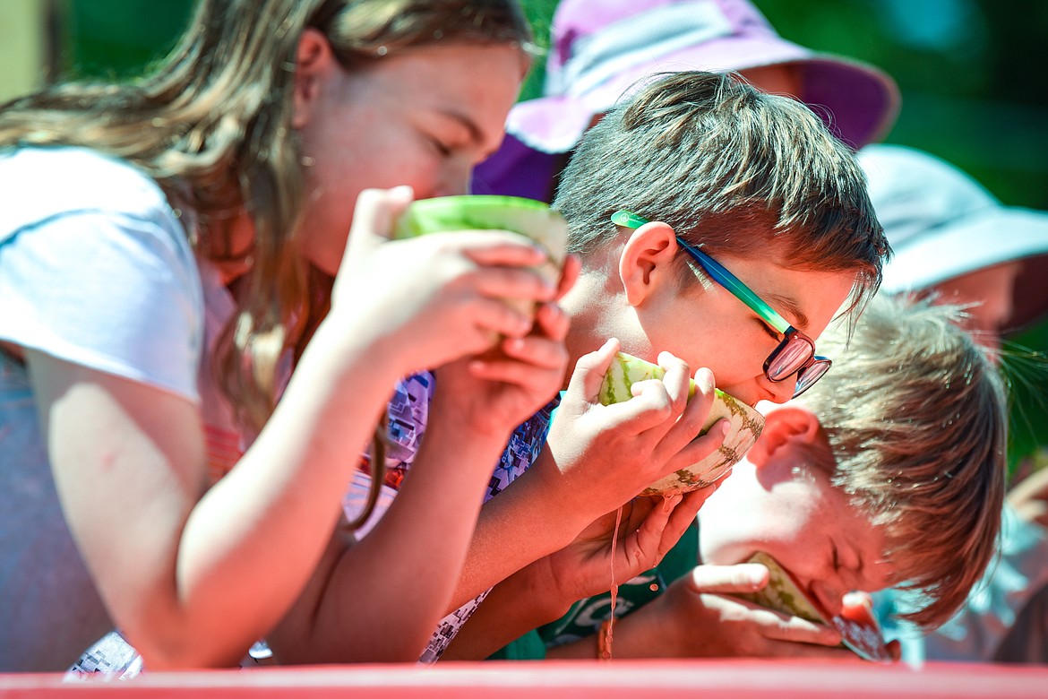 Ford Darrow, center, bites into a slice of watermelon during the kids watermelon eating contest at the Lakeside Community Fair on Saturday, July 9. Darrow won first place in his division. (Casey Kreider/Daily Inter Lake)