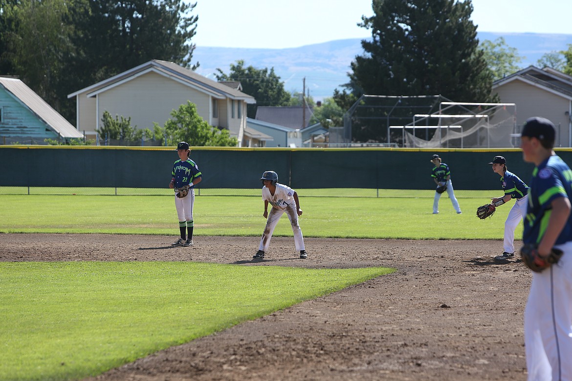 Amid a sea of defenders, a 13U Riverdog baserunner looks to advance to third base against the Venom.