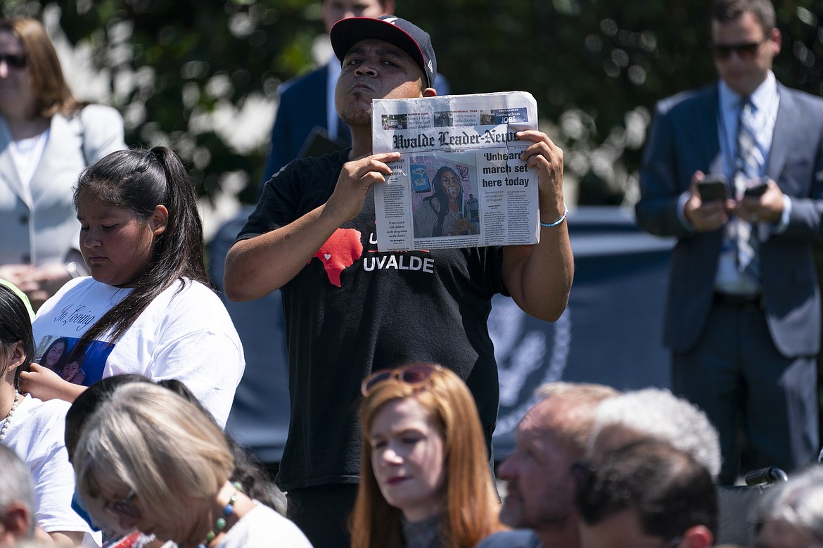 A man holds up a copy of the Uvalde Leader-News as President Joe Biden speaks during an event to celebrate the passage of the "Bipartisan Safer Communities Act," a law meant to reduce gun violence, on the South Lawn of the White House, Monday, July 11, 2022, in Washington. (AP Photo/Evan Vucci)